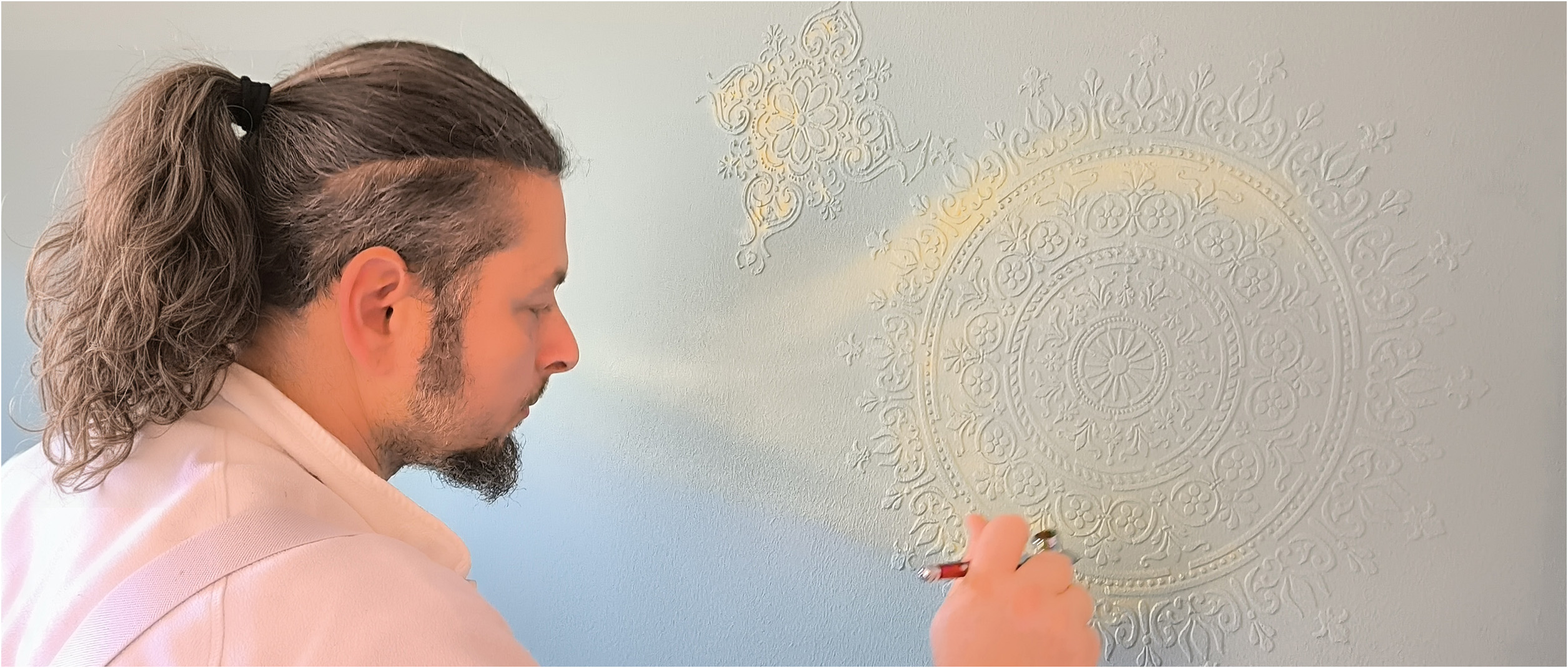 Stefan Dron arbeitet an Wandtapete